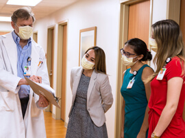Male doctor showing patient chart to small group of female interns