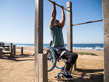 Leonard Harmon, who suffered a spinal cord injury, does pull ups while buckled to his wheelchair.